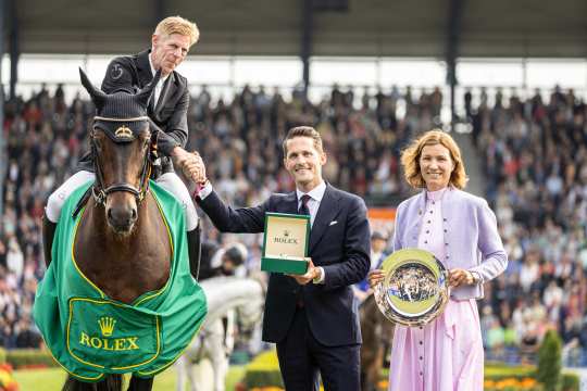 Das Foto zeigt den Sieger des Rolex Grand Prix beim CHIO Aachen 2023, Marcus Ehning, gemeinsam mit Rémi Corpataux (Geschäftsführer Rolex Deutschland GmbH) und ALRV-Präsidentin Stefanie Peters. Foto: CHIO Aachen/Jasmin Metzner