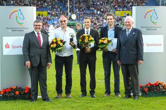 Helmut Schiffer, Executive Director of the Rheinischer Sparkassen- & Giroverband (left) and Hans Kauhsen, member of the ALRV Supervisory Board, congratulating the winner Christophe Bricot (2.f.l.). (Photo: CHIO Aachen/Michael Strauch).