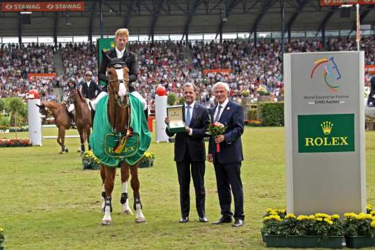 Dem Sieger Marcus Ehning gratulieren Rafael Rolli, Geschäftsführer Rolex Deutschland GmbH, und ALRV-Präsident Carl Meulenbergh. Foto: CHIO Aachen/ Michael Strauch