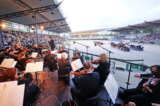 The photo shows the Aachen Symphony Orchestra under the direction of the General Music Director, Christopher Ward, during the Horse & Symphony concert in 2022. Photo: CHIO Aachen/Andreas Steindl