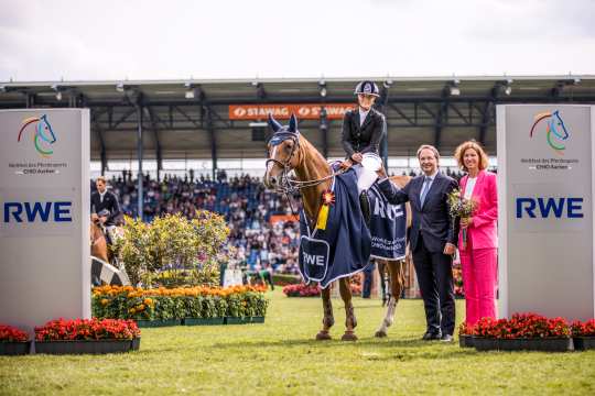 The photo shows the winner Jana Wargers together with Dr. Frank Weigand (Chairman of the Board of RWE Power AG) and ALRV President Stefanie Peters. Photo: CHIO Aachen/Franziska Sack