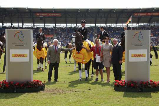  The winner is congratulated by Katja Busch, Chief Commercial Officer DHL and Carl Meulenbergh, President of the Aachen-Laurensberger Rennverein e.V. (right) and Breido Graf zu Rantzau, President of the National Federation. 