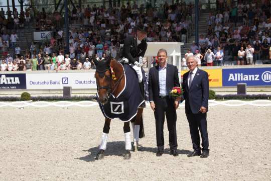 Isabell Werth is congratulated by Christian Sewing, chairman of the board Deutsche Bank AG and Carl Meulenbergh, President of the Aachen-Laurensberger Rennverein e.V. (right).