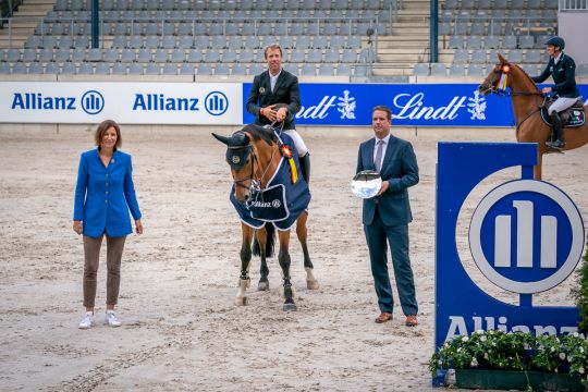 Dem Sieger gratulieren Oliver Leber, Leitung Vertriebsdirektion Köln der Allianz und Stefanie Peters, Präsidentin des Aachen-Laurensberger Rennvereins e. V.. Foto: Aachen International Jumping/ Arnd Bronkhorst