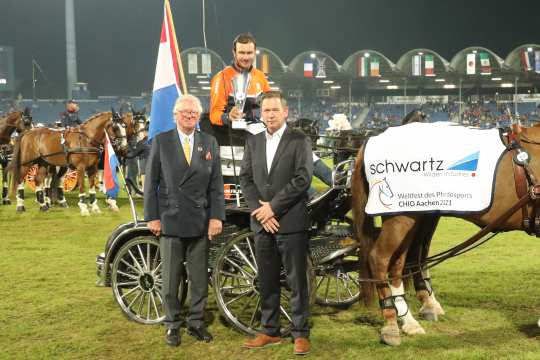 Benjamin Wilden, sales manager and member of the management of schwartz GmbH and ALRV Vice President Baron Wolf von Buchholtz (left) congratulate the winner. (Photo: CHIO Aachen / Michael Strauch).