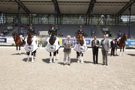 Der Siegerin gratulieren Breido Graf zu Rantzau (v.l.), sowie der U25 Reiter Sebastian Heinze und Chairman des FEI Dressage Komitees, Frank Kemperman.