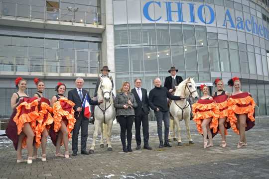 It shows f.t.l. Carl Meulenbergh, Dr. Angelika Ivens, Frank Kempermann and Uwe Brandt, framed by Angela Egert and Uli Höfert from the “Liberté Stud“ in Königswinter with their Camargue horses and cancan dancers from the Dance Company TNBOOM of Marga Render. Photo: CHIO Aachen/Holger Schupp