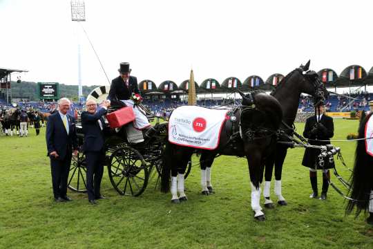 The winner is congratulated by Baron Wolf von Buchholtz und Wolfgang "Tim" Hammer (f.t.l.).