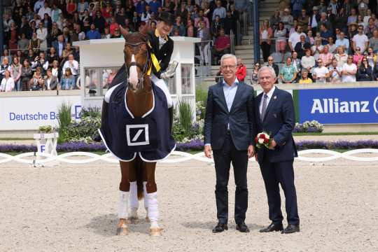 Isabell Werth is congratulated by Karl von Rohr, Deputy Chairman of the Executive Board of Deutsche Bank, and  Carl Meulenbergh. President of the Aachen-Laurensberger e.V. 