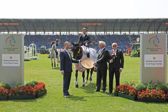 The winner is congratulated by Dieter Philipp, Peter Decker (left) and Wolfgang "Tim" Hammer (right).