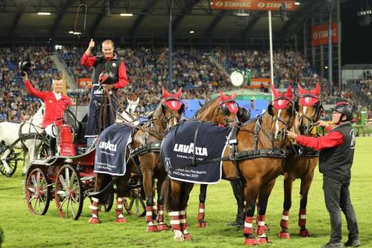 The winning team is congratulated by Karen Laesch, Marketing Director Lavazza, and Baron Wolf von Buchholtz, Vice President Aachen-Laurensberger Rennverein. 