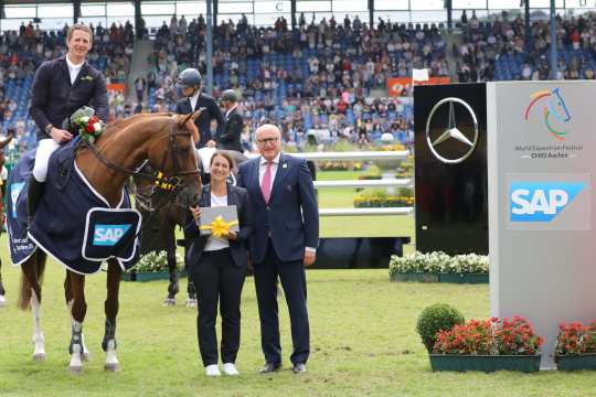 The winner is congratulated by Aileen Trunk, SAP equestrian sponsoring, and Wolfgang "Tim" Hammer, member of the ALRV supervisory board.