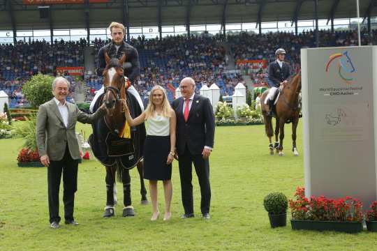 Jochen Kienbaum, Vorstandsvorsitzender der Stiftung Deutscher Spitzenpferdesport, und Marie-Claire Müter, Unterstützerin von Deutschlands U25 Springpokals der Stiftung Deutscher Spitzenpferdesport, sowie ALRV-Aufsichtsratsmitglied Wolfgang "Tim" Hammer gratulieren  dem glücklichen Sieger.