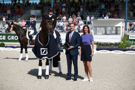 Mr. James von Moltke, Chief Financial Officer Deutsche Bank AG, and Stefanie Peters, President of the ALRV, congratulate the beaming Isabell Werth in the Deutsche Bank Stadium. Photo: CHIO Aachen / Michael Strauch