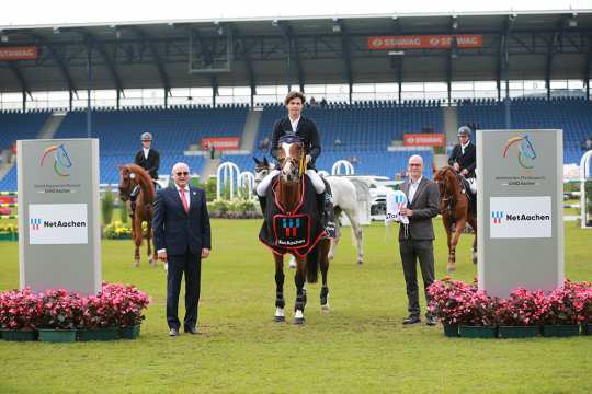 v.l.: ALRV-Aufsichtsratsmitglied Wolfgang "Tim" Hammer und NetAachen-Geschäftsführer Andreas Schneider gratulieren dem glücklichen Sieger. Foto: CHIO Aachen/Michael Strauch