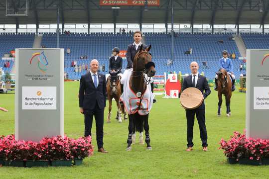 Herr Jürgen Petershagen, Mitglied des ALRV-Aufsichtsrats, und Herrn Marco Herwartz, Präsident der  Handwerkskammer Aachen, gratulieren dem Sieger Felipe Amaral. Foto: CHIO Aachen/Michael Strauch