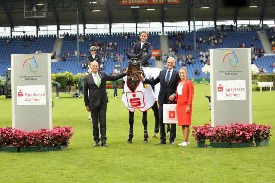 Ralf Wagemann Vorstandsmitglied der Sparkasse Aachen, und ALRV-Aufsichtsratsmitglied Jürgern Petershagen gratulieren Darragh Kenny. Foto: CHIO Aachen/ Michael Strauch