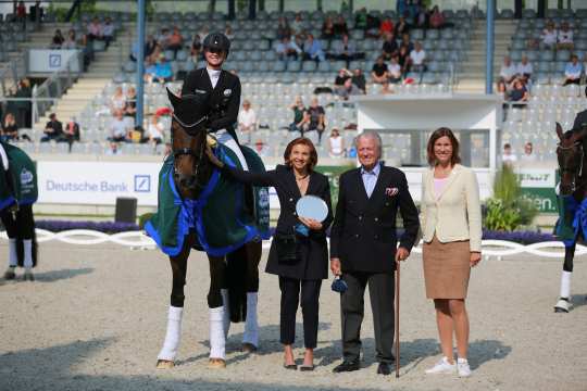From left: Ms. Marina Meggle, deputy Chairwoman of the Management Board of the Toni Meggle Foundation, Mr. Toni Meggle, Chairman of the Management Board of the Toni Meggle Foundation, and ALRV President Stefanie Peters congratulate the winner in the Deutsche Bank Stadium. Photo: CHIO Aachen / Michael Strauch