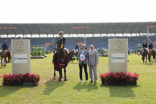 From left: Mr. Andreas Schneider, Managing Director of NetAachen GmbH, and Mr. Wolfgang "Tim" Hammer congratulate the lucky winner. Photo: CHIO Aachen / Michael Strauch