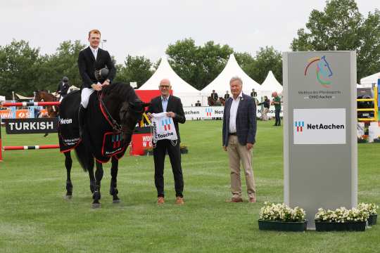 Andreas Schneider, Geschäftsführer der NetAachen GmbH, und CHIO Aachen Turnierdirektor Frank Kemperman, gratulieren dem Sieger. Foto: CHIO Aachen/Michael Strauch