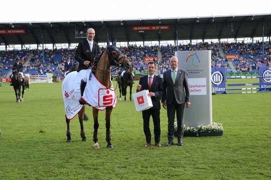 from left: Dr. Christian Burmester, Deputy CEO of the Sparkasse Aachen, and Jürgen Petershagen, congratulate the winner. Photo: CHIO Aachen/Michael Strauch