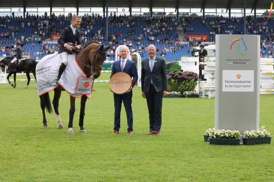 From left: Marco Herwartz, President of the Aachen Chamber of Crafts, and ALRV member Jürgen Petershagen congratulate the winner. Photo: CHIO Aachen/Michael Strauch