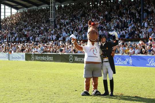 The CHIO Aachen mascot Karli and Dressage rider Juan Matute Guimón also wave a white handkerchief in farewell.