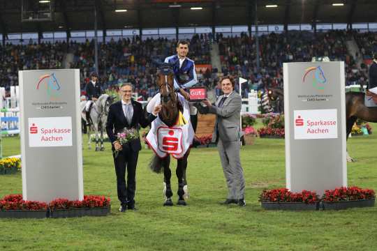 The photo shows the winner Nicola Philippaerts together with Norbert Laufs (Chairman of the Board of Sparkasse Aachen) and ALRV Supervisory Board member Dr. Thomas Förl. Photo: CHIO Aachen/Michael Strauch