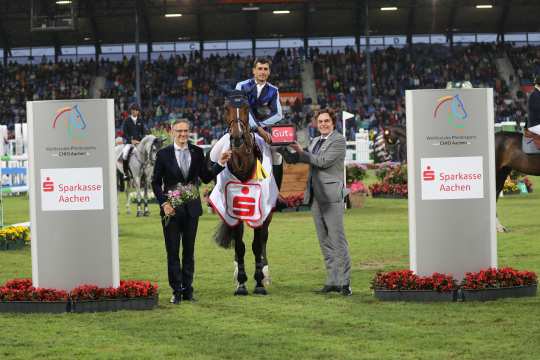 Das Foto zeigt den Sieger Nicola Philippaerts gemeinsam mit Norbert Laufs (Vorstandsvorsitzender der Sparkasse Aachen) und ALRV-Aufsichtsratsmitglied Dr. Thomas Förl. Foto: CHIO Aachen/Michael Strauch