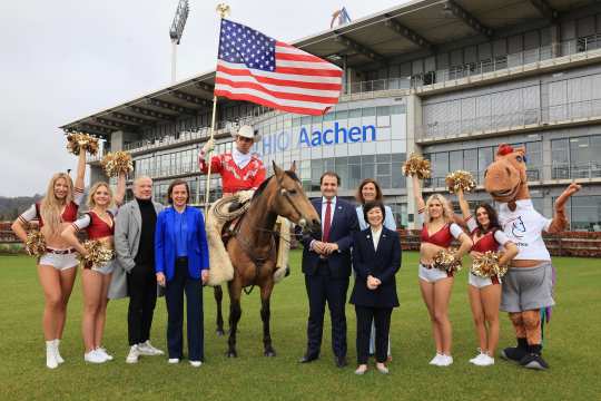 Das Foto zeigt die Protagonisten der Pressekonferenz anlässlich der Vorstellung des Partnerlands beim CHIO Aachen 2024. Eingerahmt von Cheerleadern der Rhine Fire Düsseldorf und CHIO Aachen-Maskottchen Karli von rechts nach links: US-Generalkonsulin Pauline Kao, ALRV-Präsidentin Stefanie Peters, NRW-Staatskanzlei-Chef Nathanael Liminski, Westernreiter Josh Clemens auf seinem Quarterhorse, ALRV-Vorstandsmitglied Birgit Rosenberg und Eröffnungsfeier-Regisseur Uwe Brandt (Foto: CHIO Aachen/Andreas Steindl).