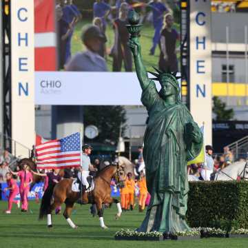 Ein Pferd, dessen Reiter eine amerikanische Flagge trägt, galoppiert bei der Eröffnungsfeier im Hauptstadion an einer riesigen Imitation der Freiheitsstatue vorbei.