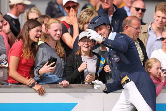 Dressurreiter Patrick Kittel macht beim Abschied der Nationen im Hauptstadion ein Selfie mit drei glücklichen Fans.