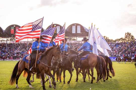 Bei der Eröffnungsfeier zeigen 8 Westernpferde ein Schaubild. Die Reiter in Westernkleidung tragen die Flagge der USA und die Flagge des CHIO.