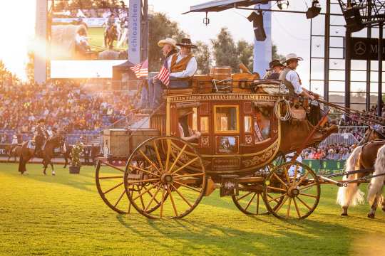 Bei einem wunderschönen Sonnenuntergang während der Eröffnungsfeier fährt die Mrs. World in einer altmodischen Kutsche durch das Hauptstadion und wird dabei von vier Cowboys begleitet.