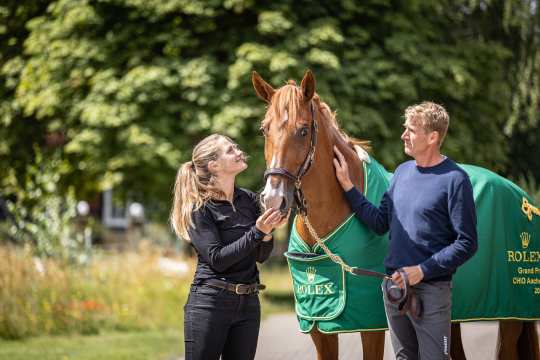 Chakaria in ihrer Siegerdecke des Rolex Grand Prix zwischen ihrer Pflegerin Heidemarie Jäckel und ihrem Reiter Andre Thieme im Grünen bei einem Stallbesuch