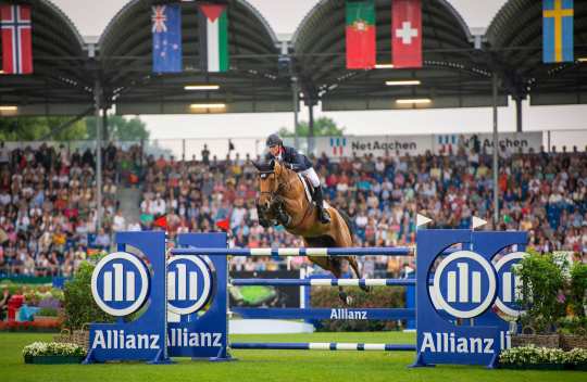 Ben Maher and his bay mare Dallas Vegas Batilly jumping over the Allianz Oxer for Team Great Britain