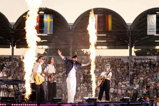 Music star Alvaro Soler on stage at the opening ceremony in the main stadium with a fantastic light show. The audience is thrilled.